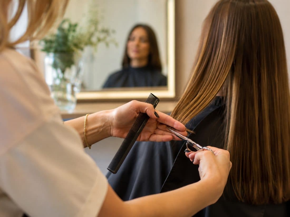 Cabeleireira finalizando o corte de uma cliente no salão